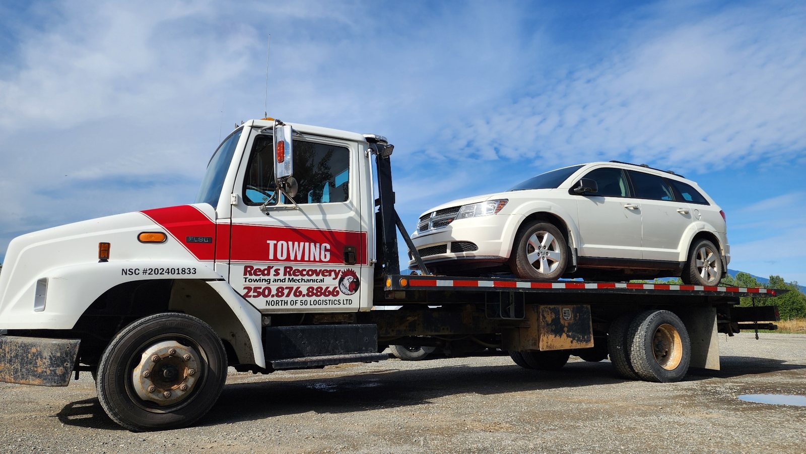 Dodge Journey secured on Red's Recovery flatbed tow truck