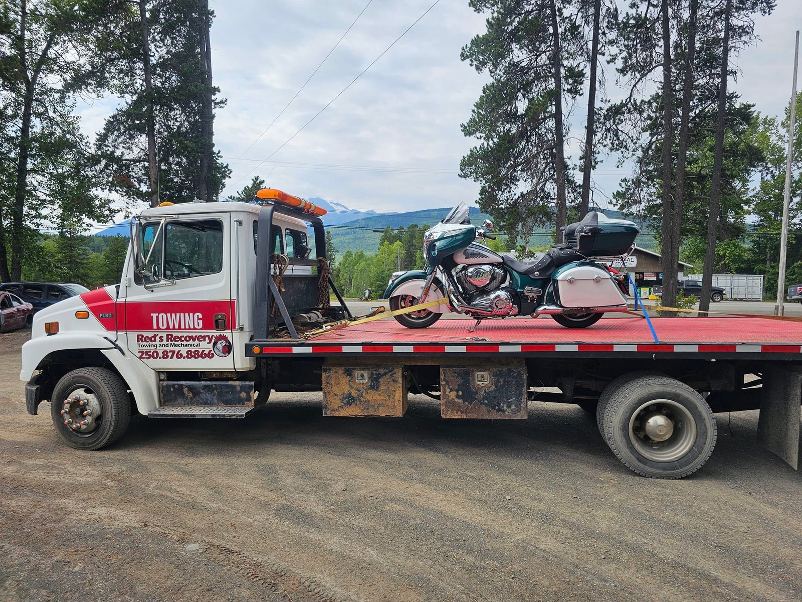 Motorcycle strapped down on Red's Recovery flatbed tow truck
