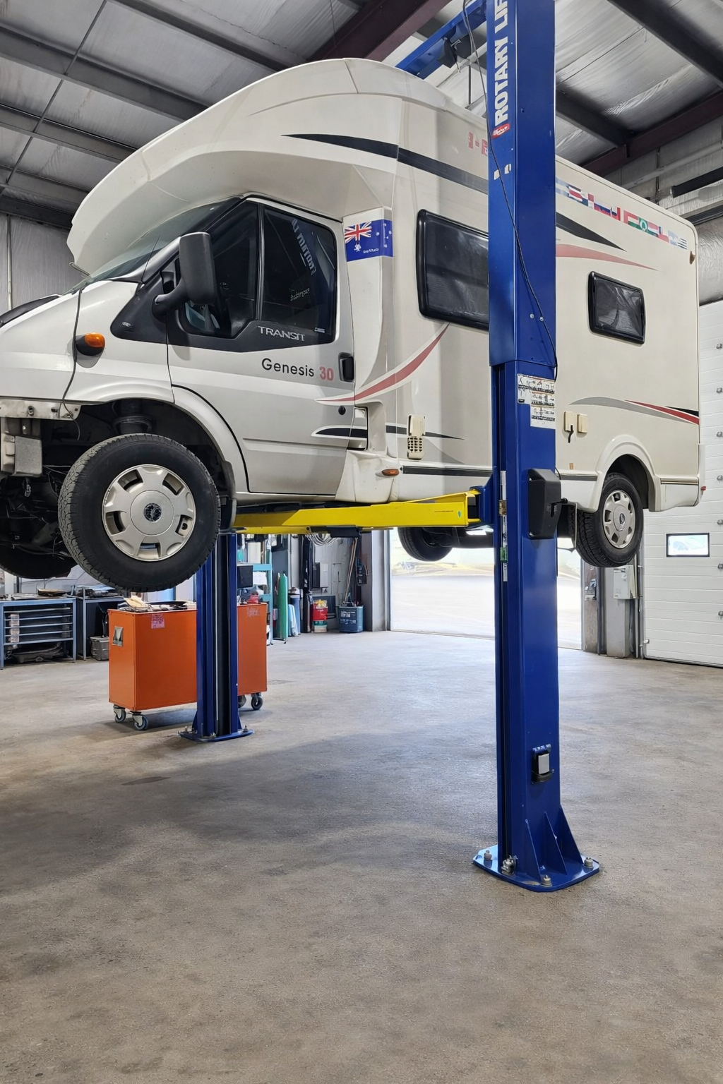 RV raised on shop hoist for mechanical service
