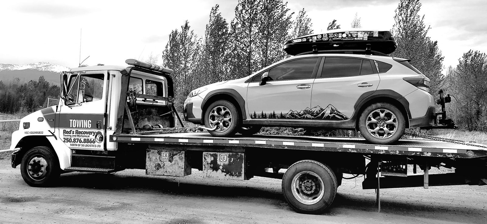 Subaru loaded on Red's Recovery flatbed tow truck